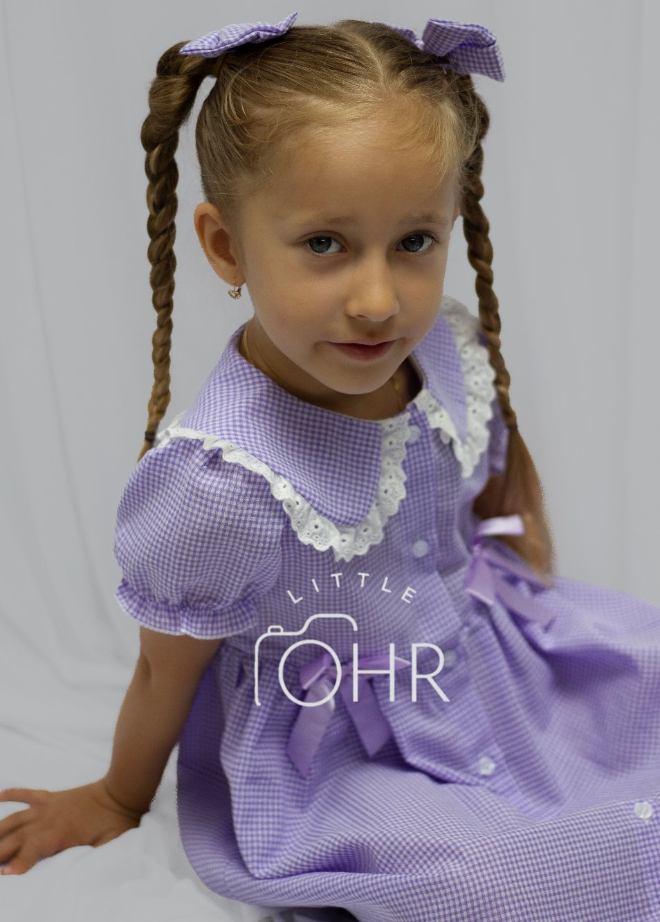 Girl with plaits in a lilac gingham summer dress